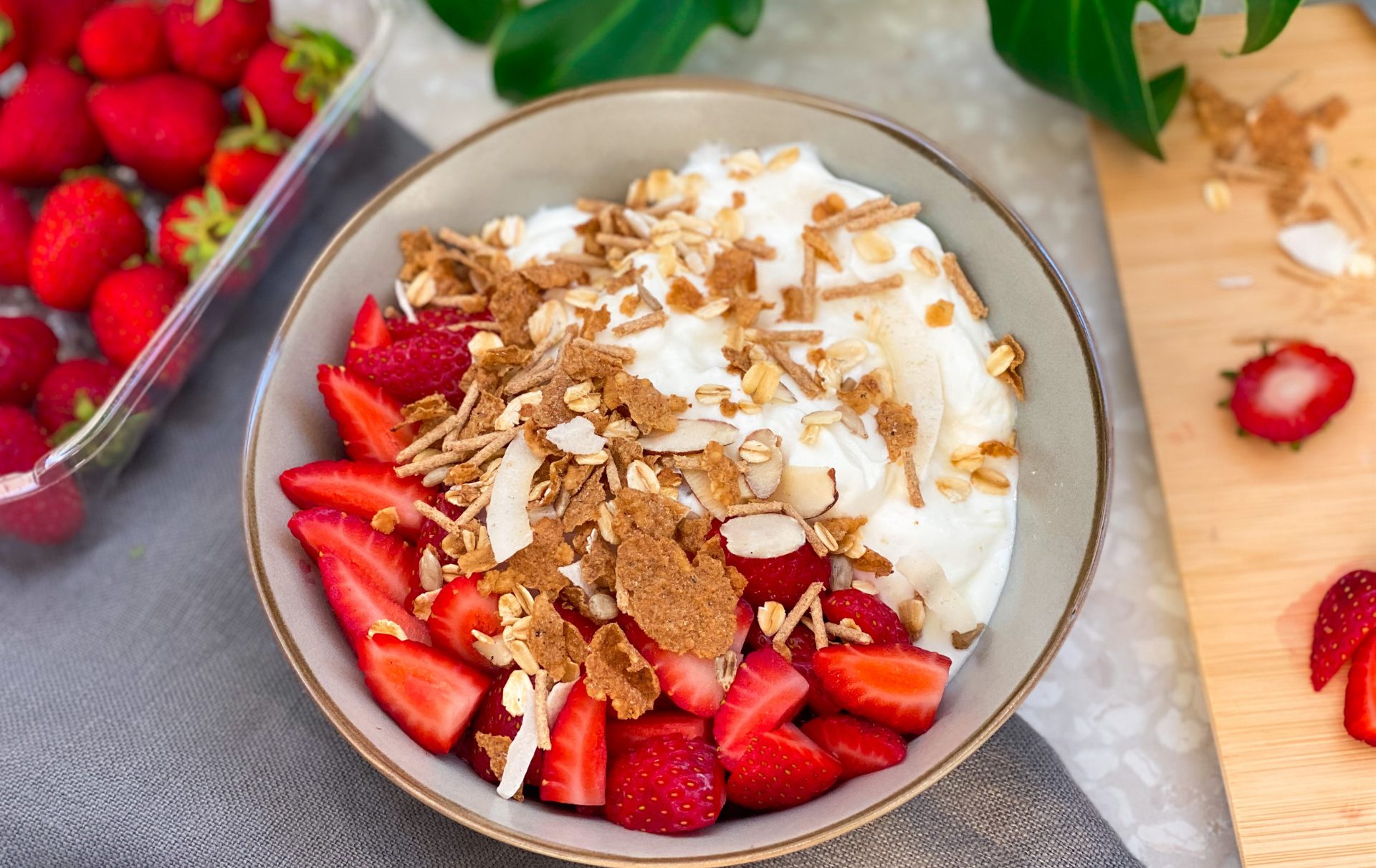 a photo of a yoghurt bowl with carman's goodness & grains cereal on top